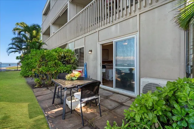a backyard of a house with table and chairs potted plants