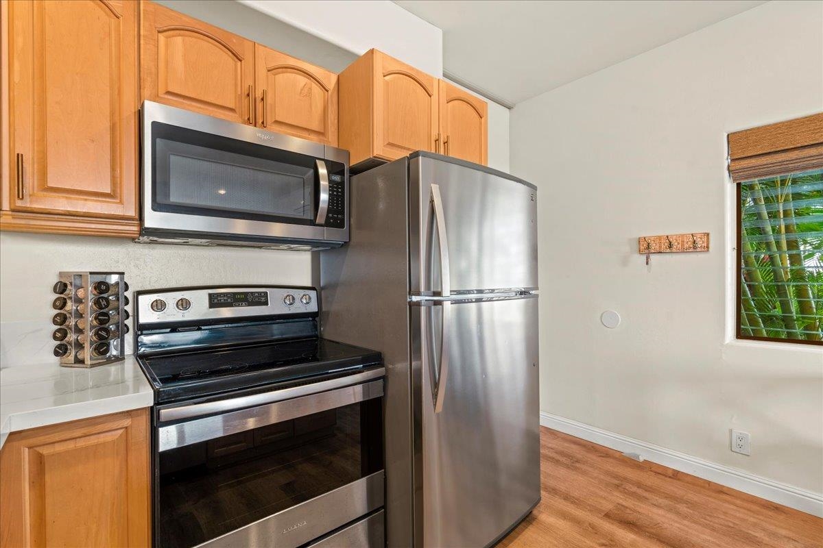 4435 Lower Honoapiilani Road, Unit 103 Lahaina, HI 96761 - Photo 27 of 34 a kitchen with granite countertop a refrigerator stove and microwave