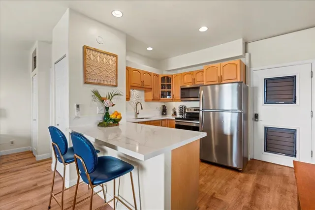 a kitchen with stainless steel appliances granite countertop a refrigerator a stove a sink a dining table and chairs