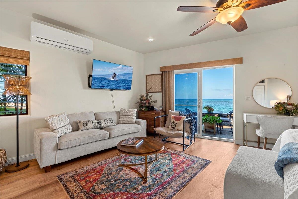 4435 Lower Honoapiilani Road, Unit 103 Lahaina, HI 96761 - Photo 7 of 34 a living room with furniture a rug and a chandelier