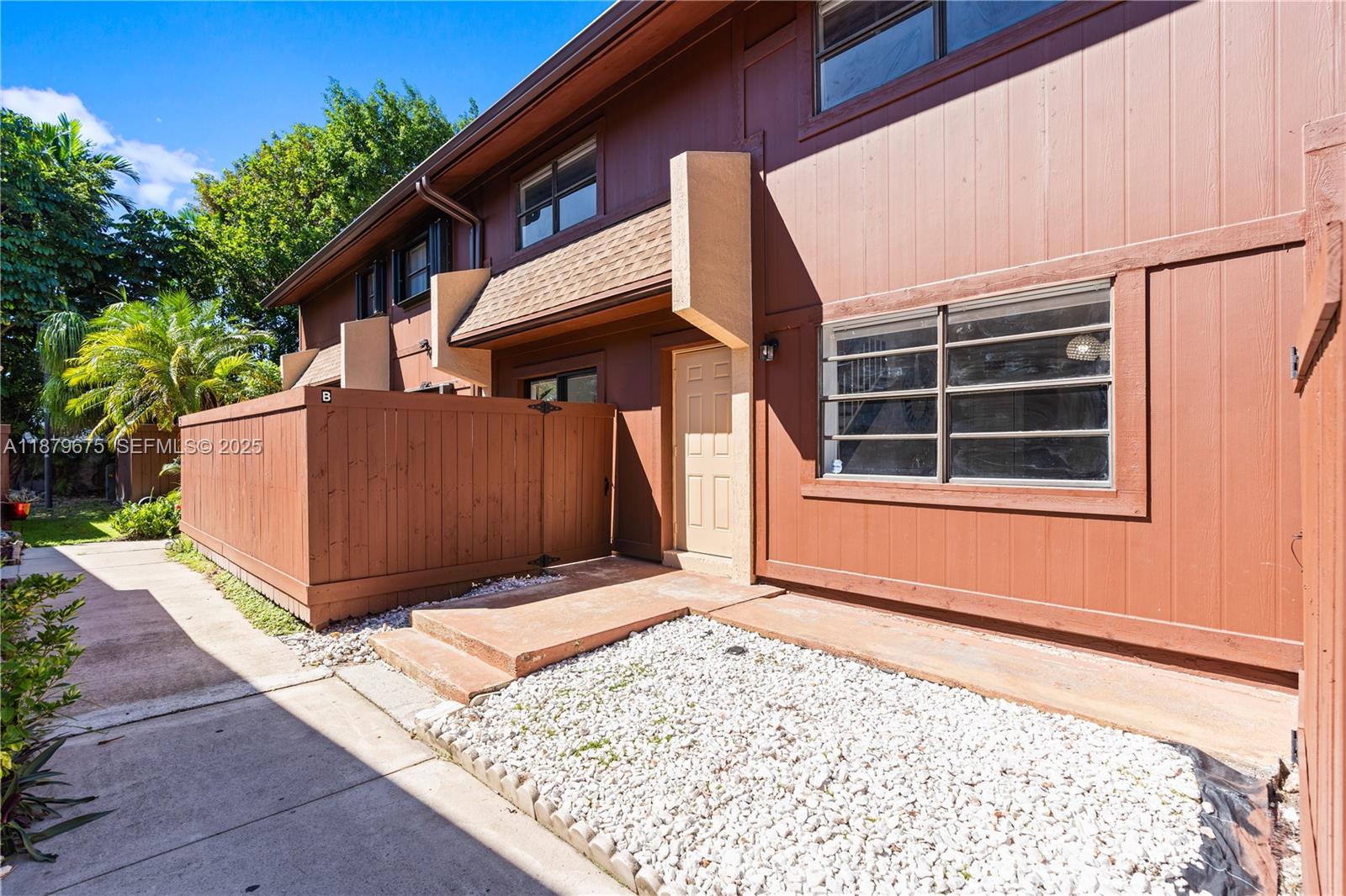 6621 Southwest 116th Place, Unit B2 Miami, FL 33173 - Photo 2 of 36 a view of backyard with large tree and wooden fence