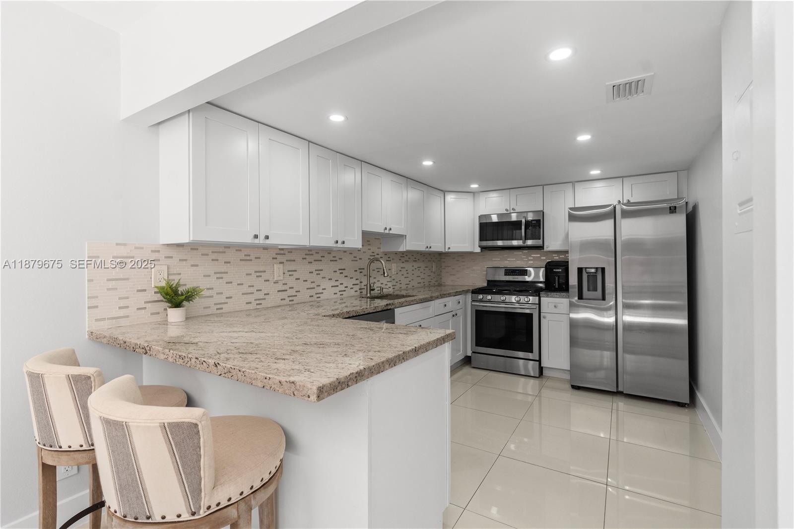 6621 Southwest 116th Place, Unit B2 Miami, FL 33173 - Photo 5 of 36 a kitchen with granite countertop stainless steel appliances cabinets a sink and a island