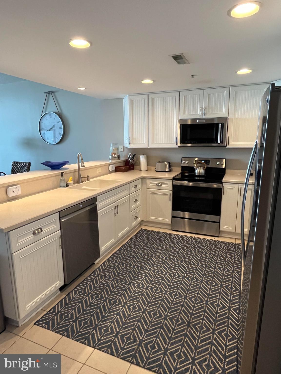 103 Williams Street, Unit 213 Crisfield, MD 21817 - Photo 13 of 25 a kitchen with a sink a stove top oven and wooden floor