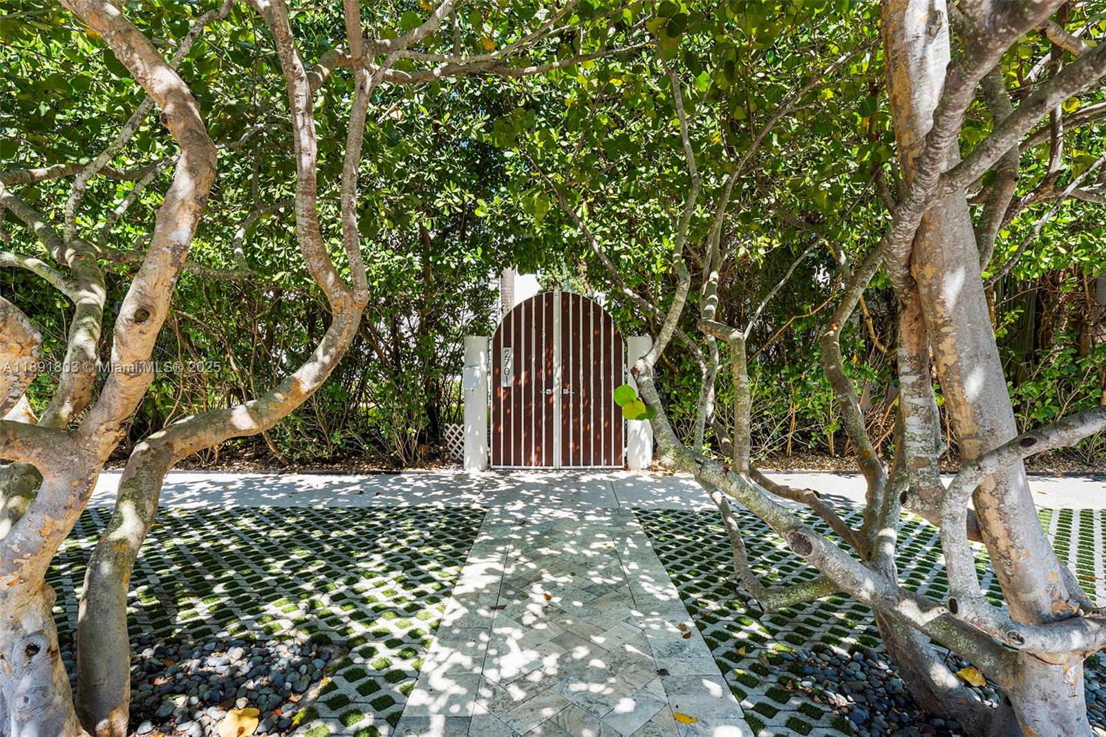 2701 North Bay Road Miami Beach, FL 33140 - Photo 6 of 38 a wooden fence with trees in the background