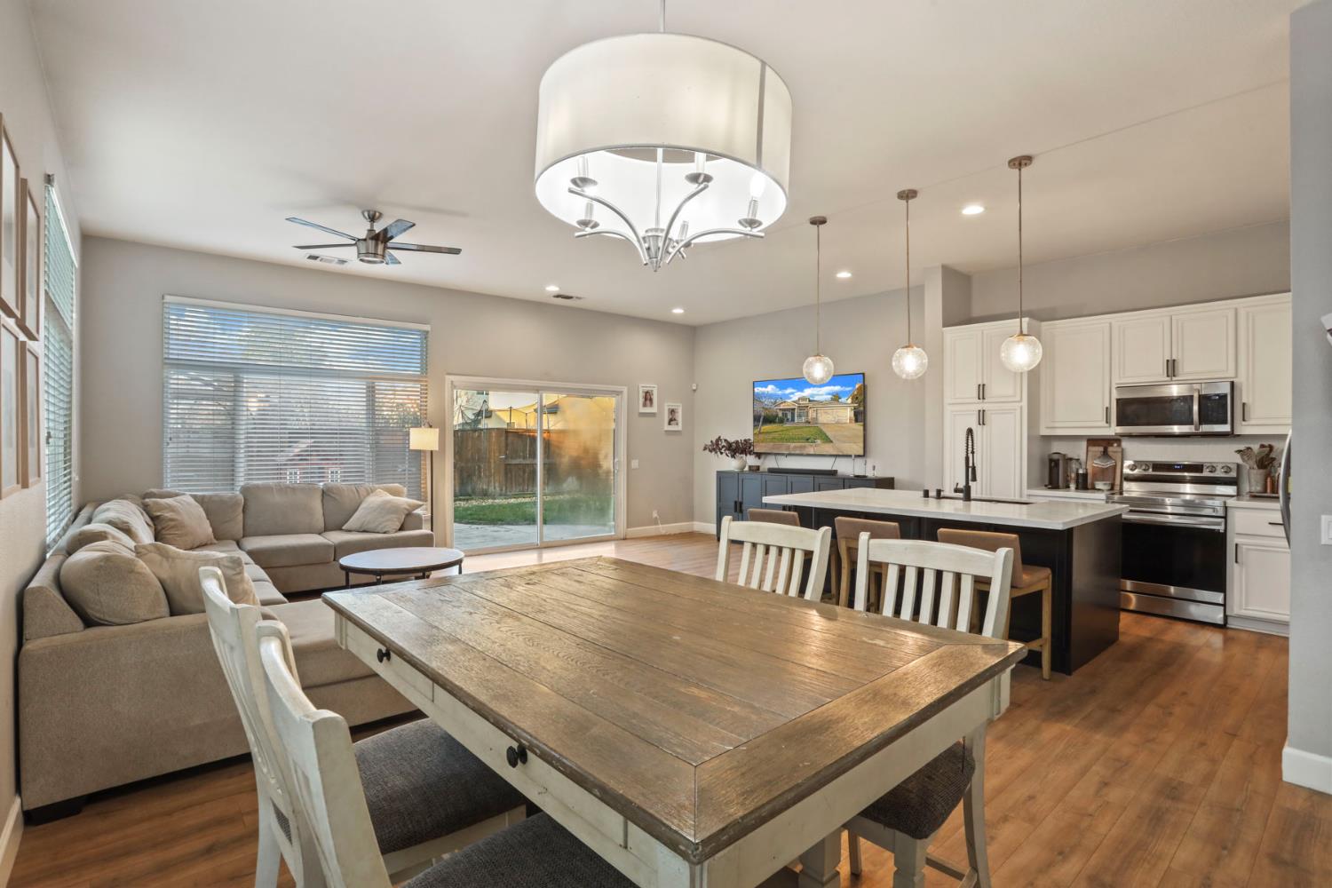 277 Fragrance Street Manteca, CA 95337 - Photo 11 of 27 a kitchen with stainless steel appliances granite countertop a stove a refrigerator a kitchen island a dining table and chairs with wooden floor