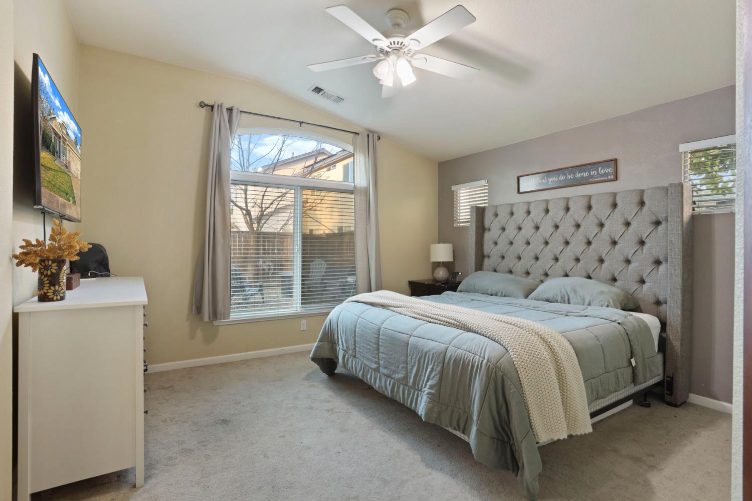 277 Fragrance Street Manteca, CA 95337 - Photo 17 of 27 a bedroom with a large bed and a flat tv screen on dresser