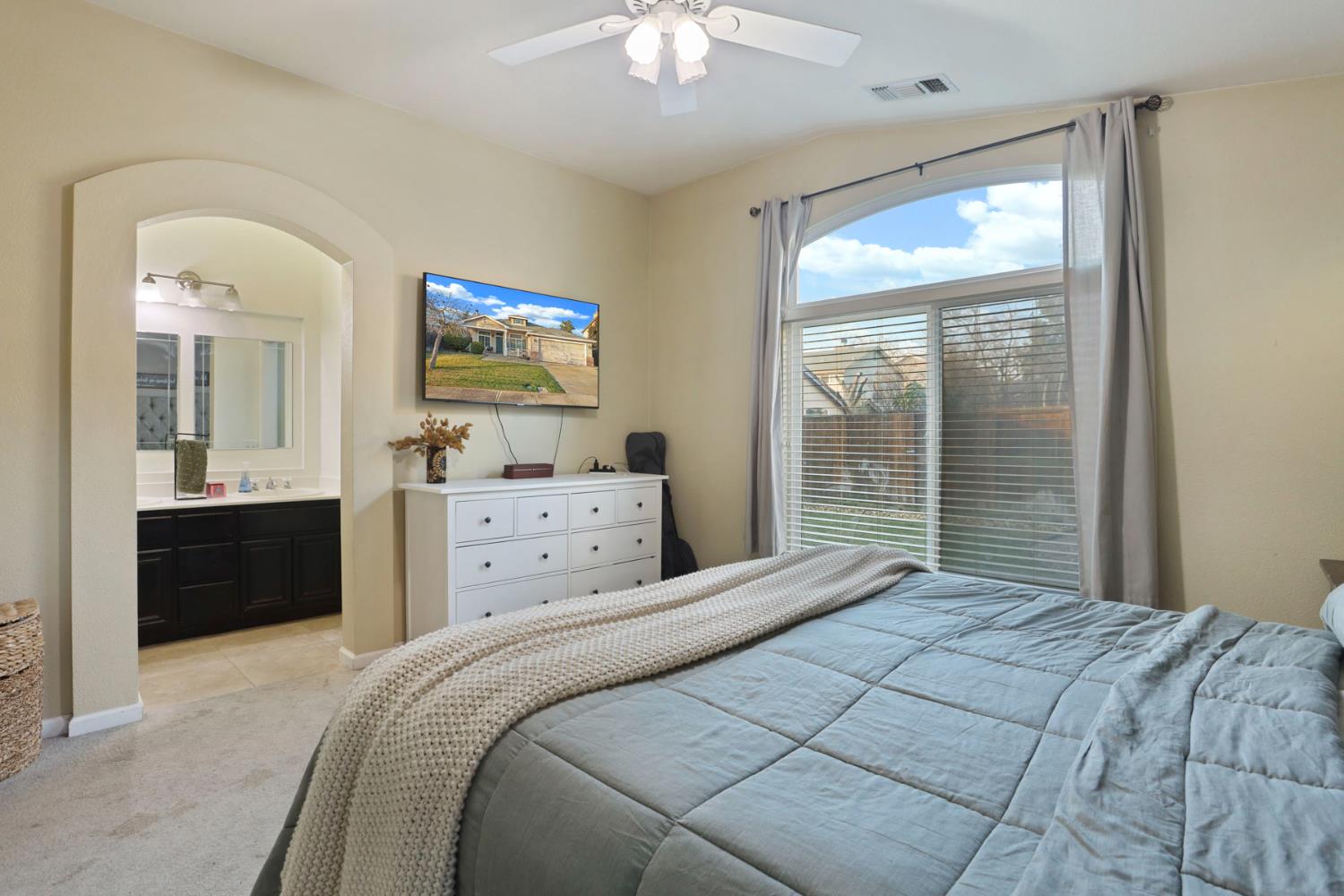 277 Fragrance Street Manteca, CA 95337 - Photo 18 of 27 a bedroom with a large bed and a chandelier