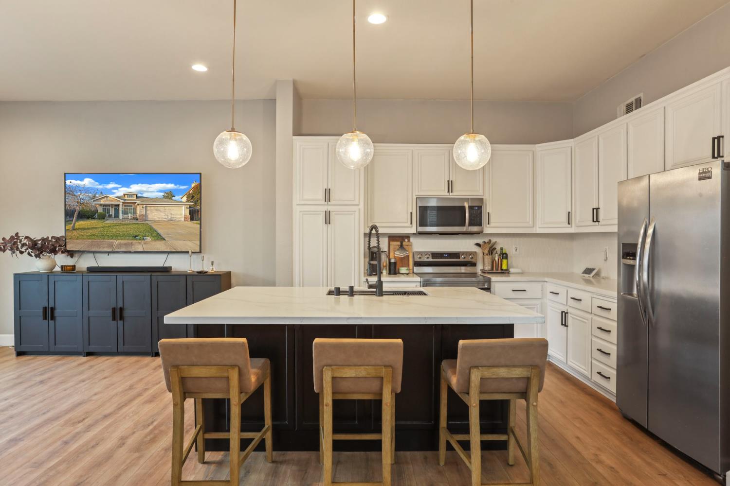 277 Fragrance Street Manteca, CA 95337 - Photo 3 of 27 a kitchen with a dining table chairs sink and cabinets