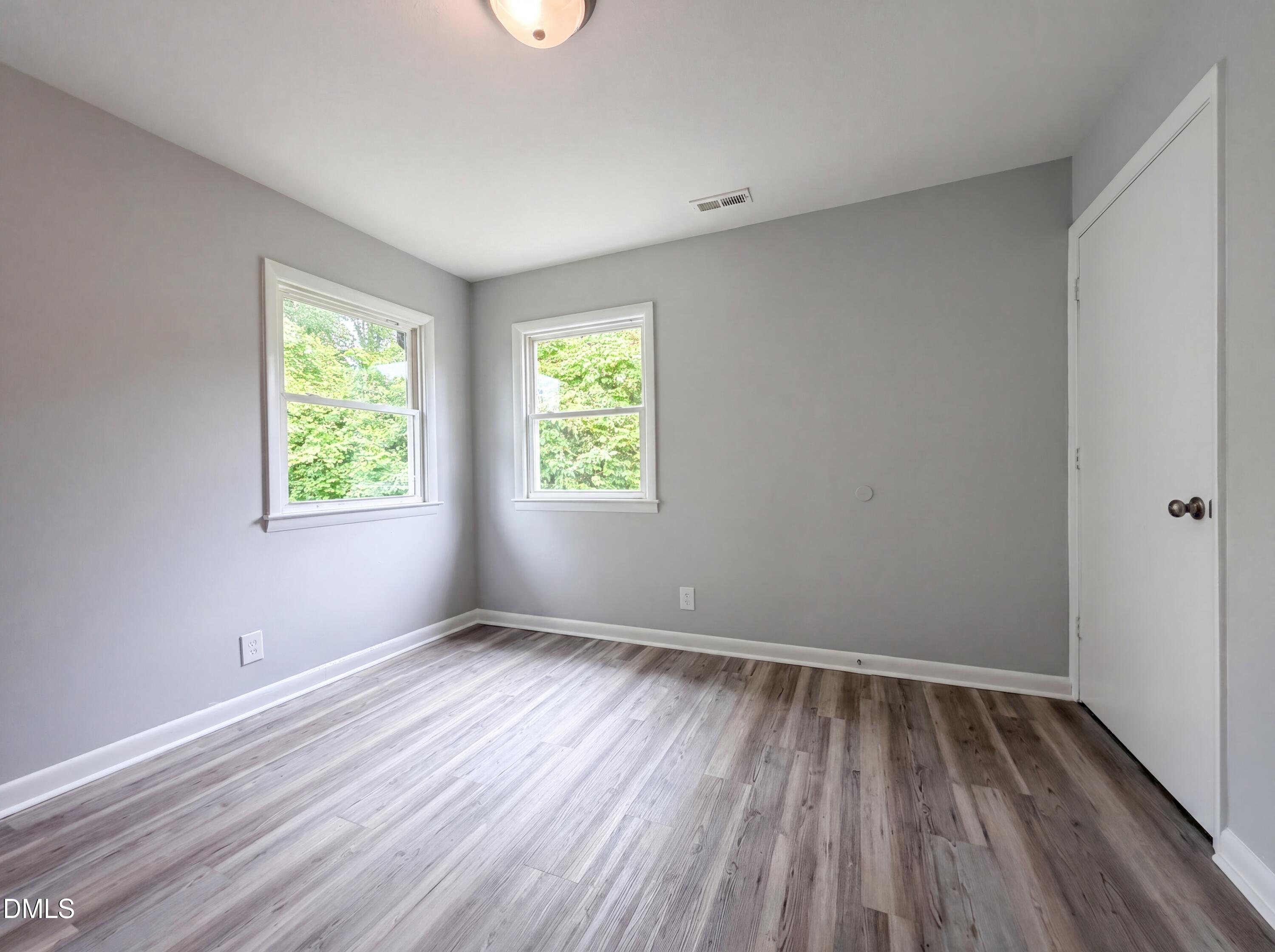 303 Stancil Street Smithfield, NC 27577 - Photo 11 of 16 an empty room with wooden floor and windows