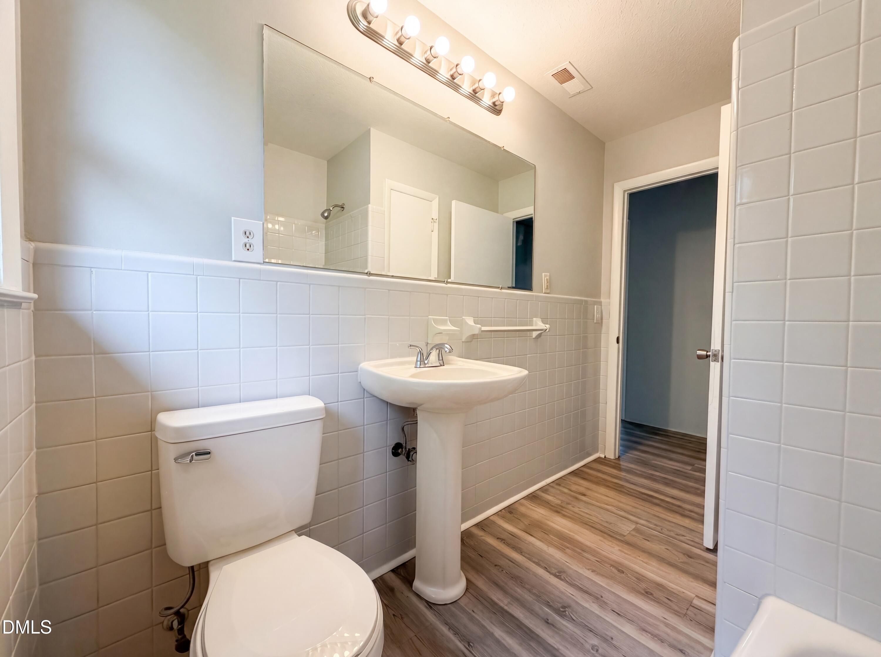 303 Stancil Street Smithfield, NC 27577 - Photo 12 of 16 a bathroom with a sink toilet and a mirror