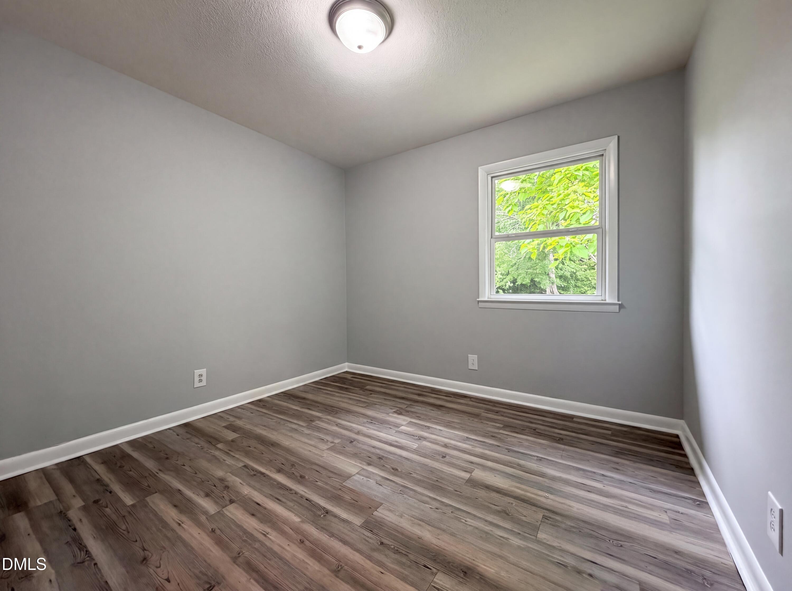 303 Stancil Street Smithfield, NC 27577 - Photo 4 of 16 wooden floor in an empty room with a window