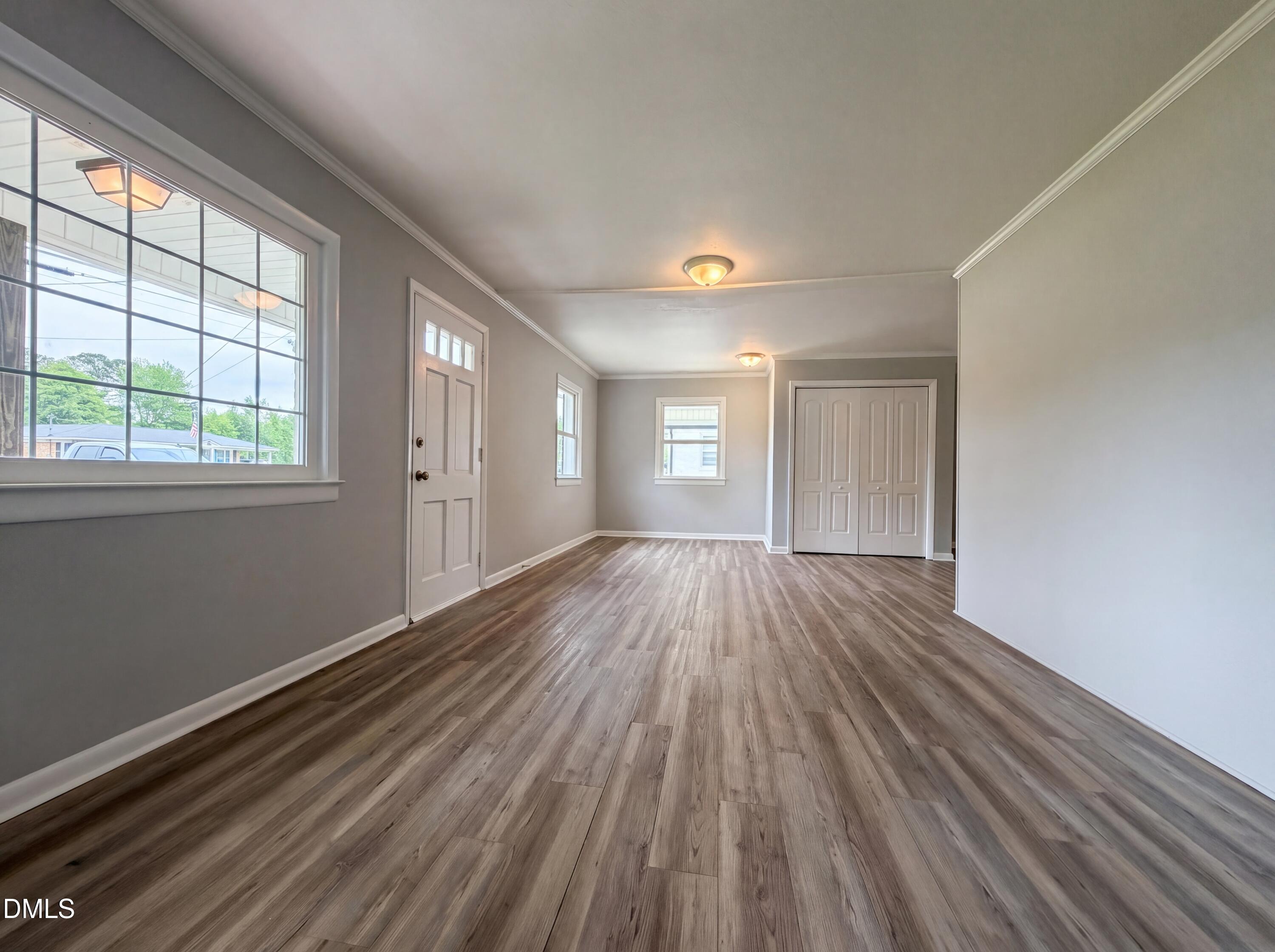303 Stancil Street Smithfield, NC 27577 - Photo 8 of 16 a view of an empty room with wooden floor and a window