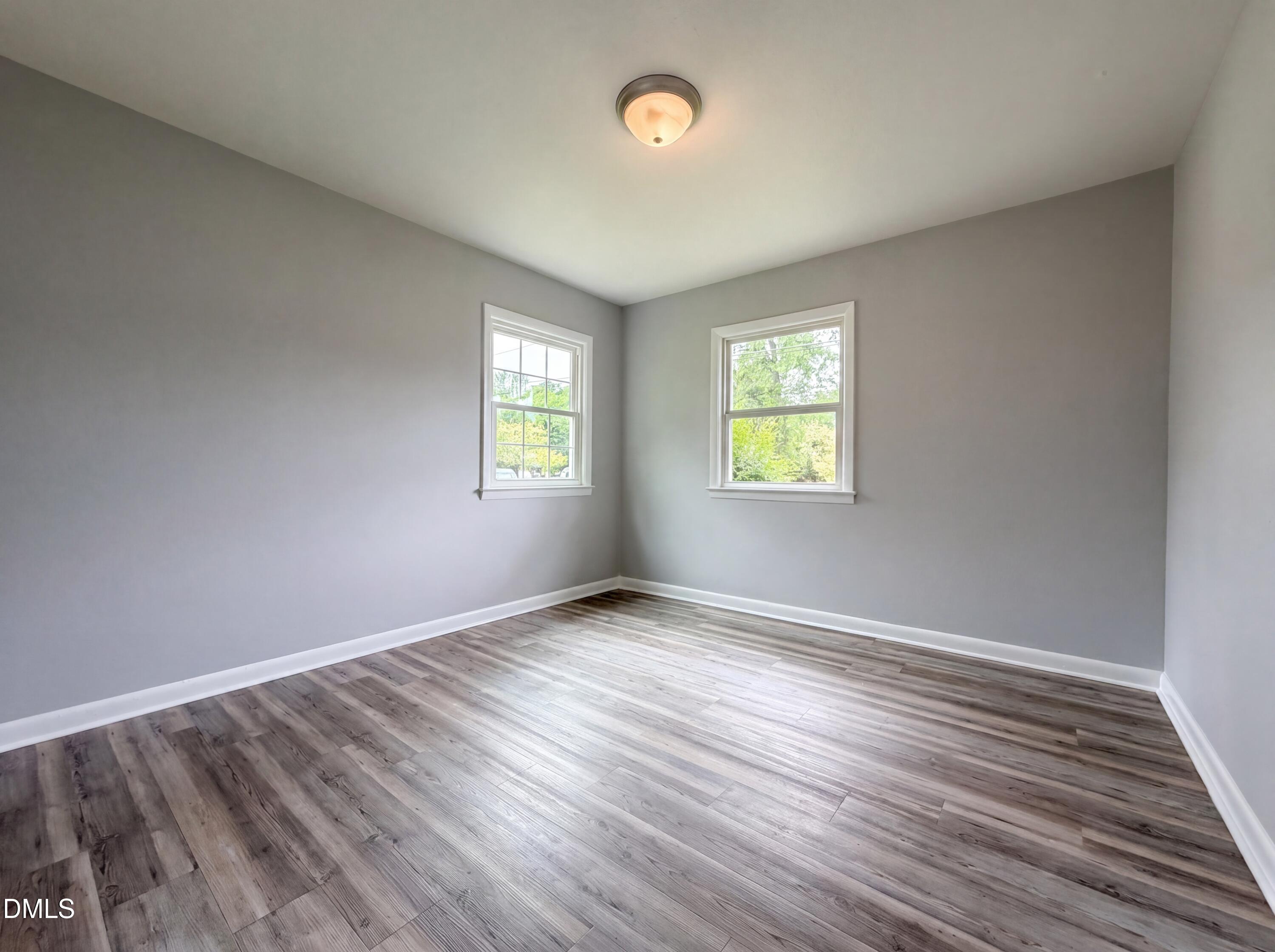 303 Stancil Street Smithfield, NC 27577 - Photo 10 of 16 an empty room with wooden floor and windows