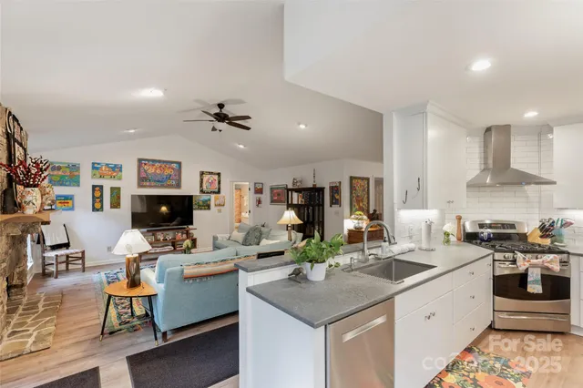 a kitchen with granite countertop a stove and white cabinets