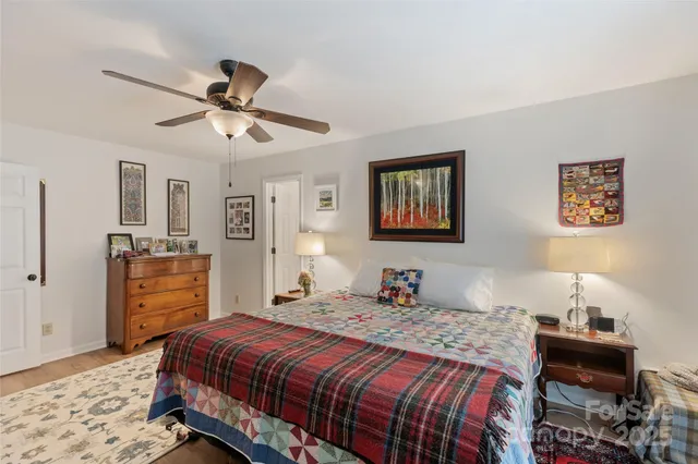 a view of a patio with couches and a table and chairs with wooden floor and fence