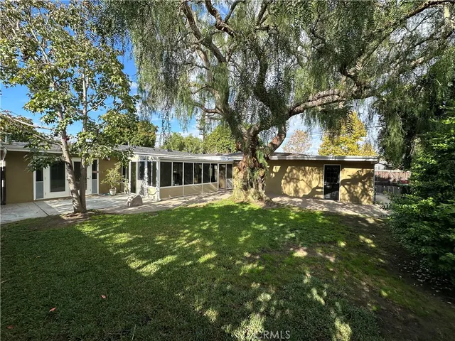 a backyard of a house with table and chairs