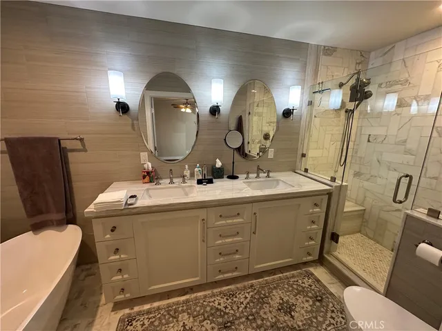 a bathroom with a double vanity sink toilet and shower
