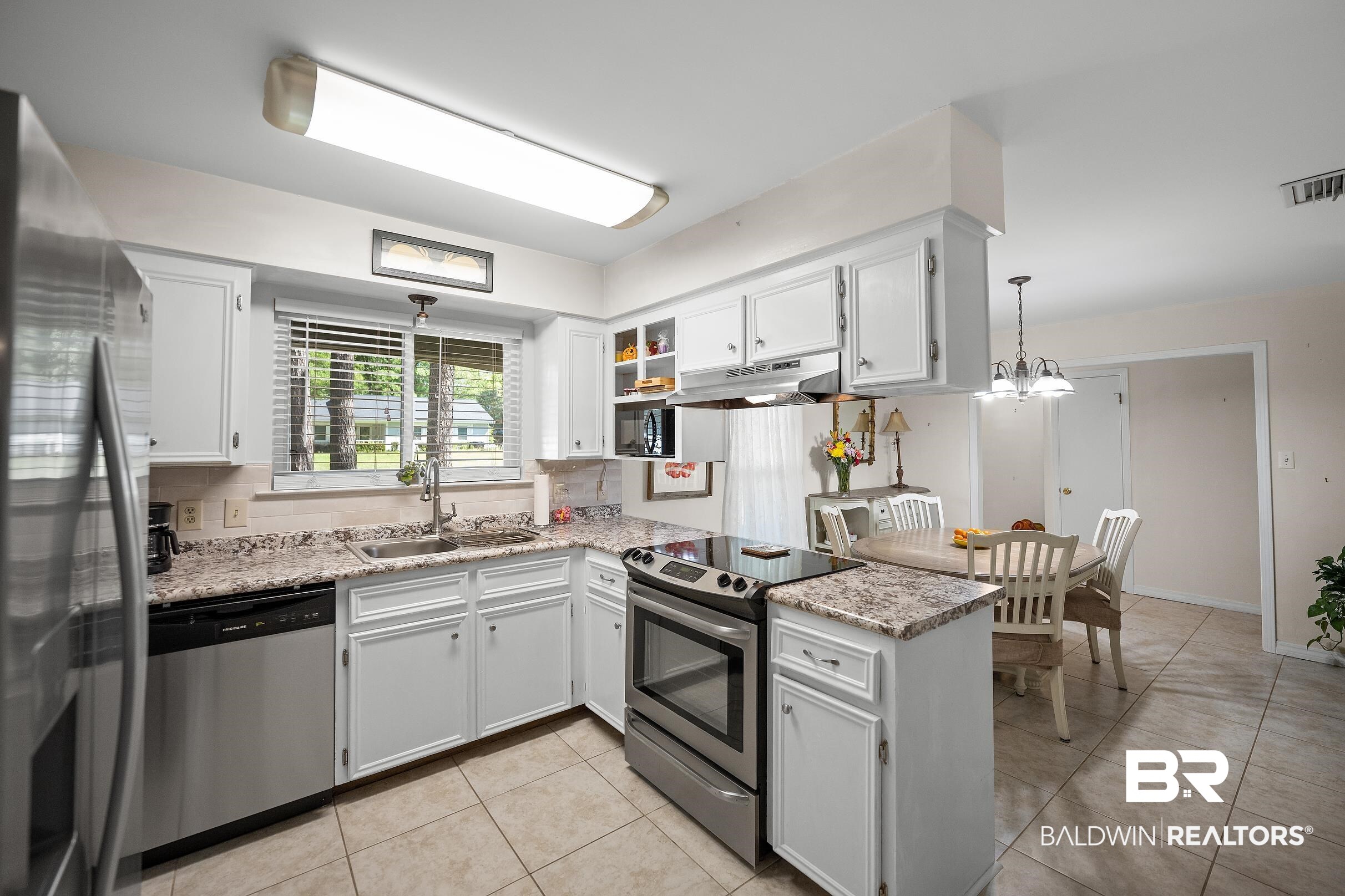 120 Dunbar Loop Daphne, AL 36526 - Photo 8 of 25 Kitchen featuring stainless steel appliances, a peninsula, white cabinets, light tile patterned floors, and backsplash