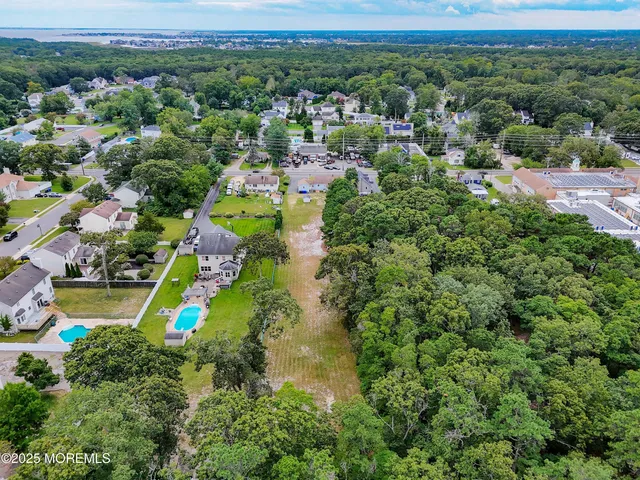 an aerial view of residential houses with outdoor space and trees
