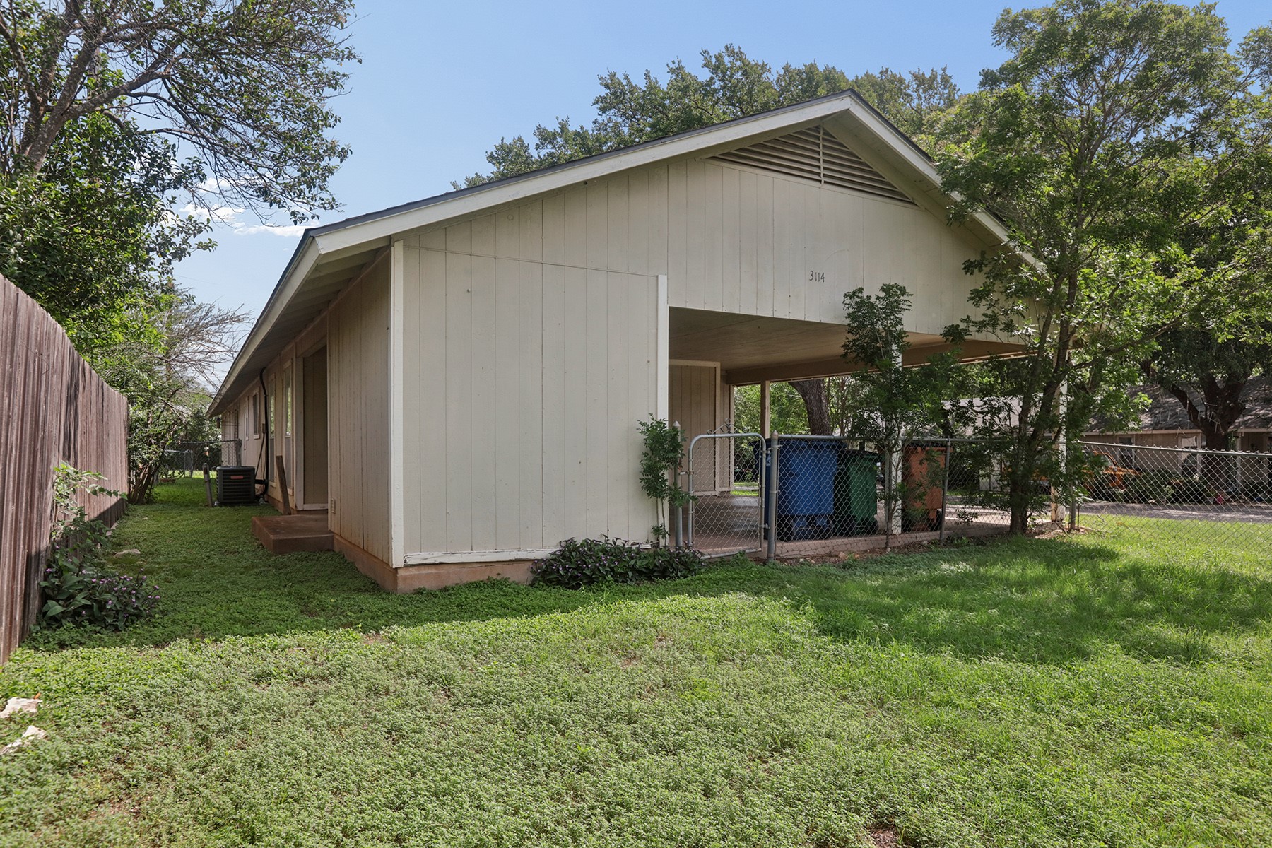 3114 Plantation Road, Unit A Austin, TX 78745 - Photo 15 of 15 A well-maintained side yard offers ample green space and a covered parking area.
