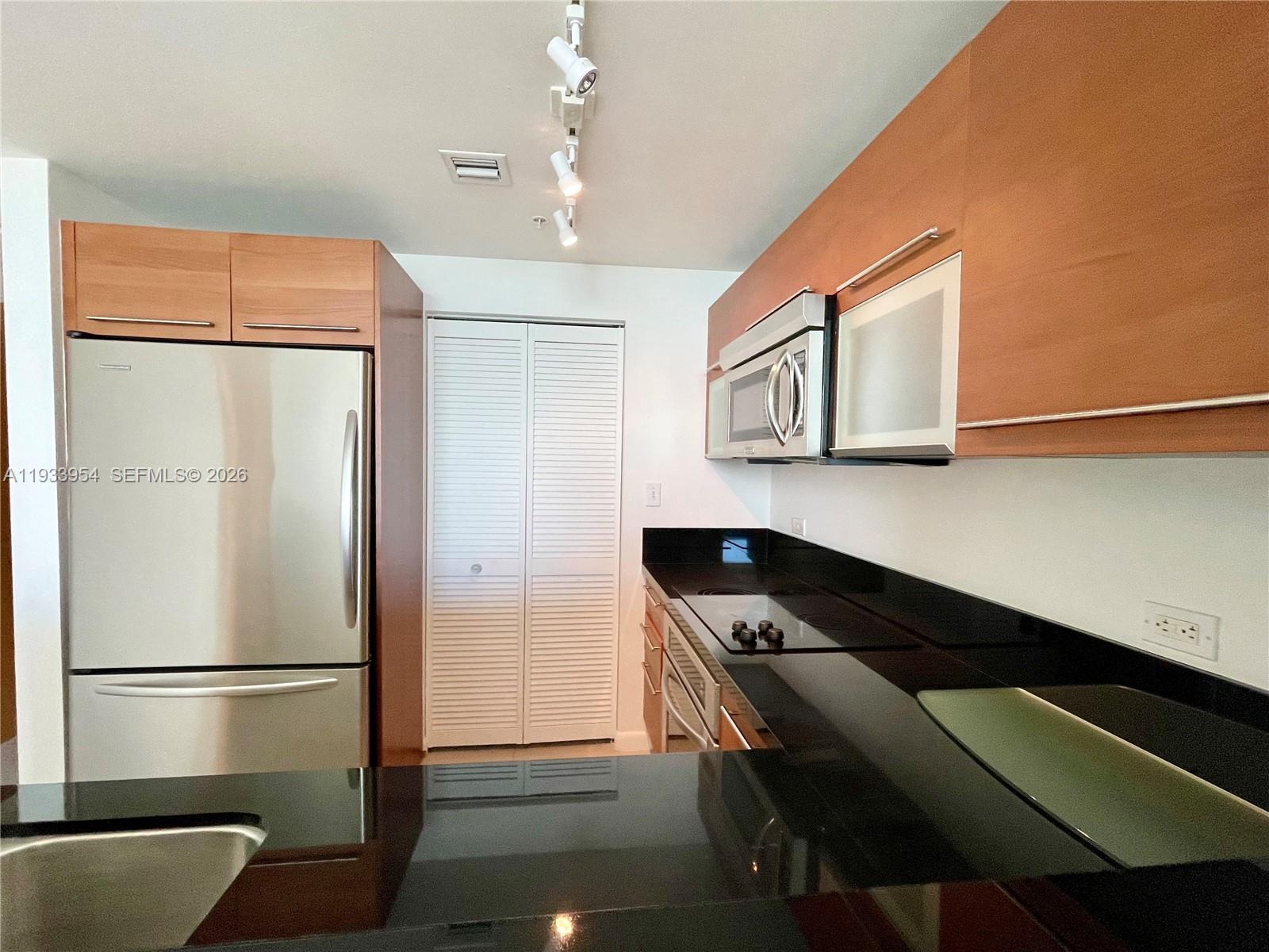 253 Northeast 2nd Street, Unit 2409 Miami, FL 33132 - Photo 13 of 61 a kitchen with a refrigerator and a stove top oven
