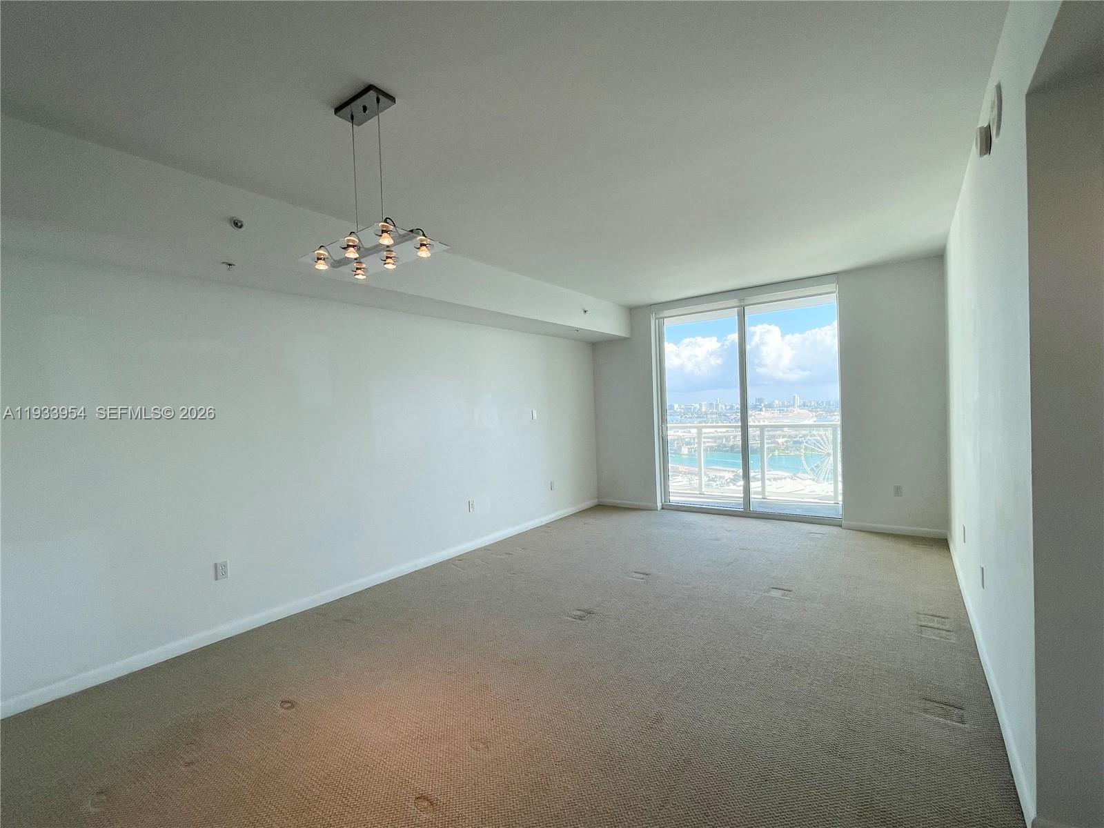 253 Northeast 2nd Street, Unit 2409 Miami, FL 33132 - Photo 16 of 61 an empty room with chandelier fan and windows