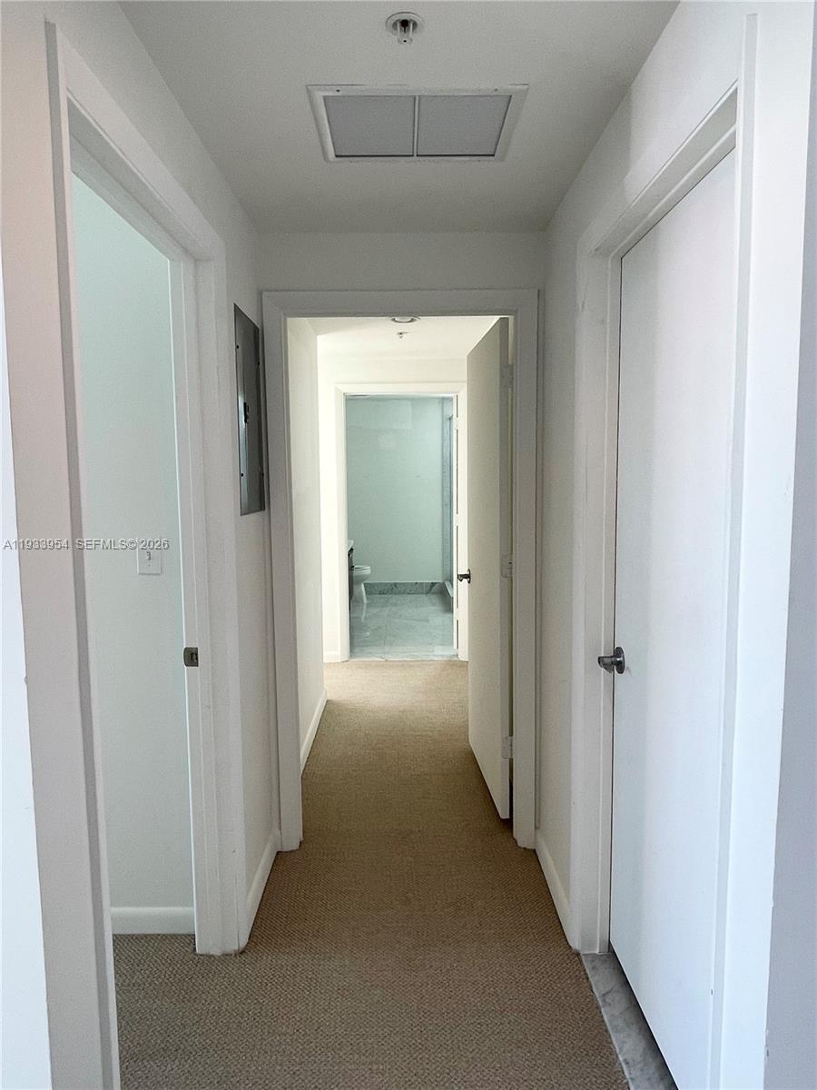 253 Northeast 2nd Street, Unit 2409 Miami, FL 33132 - Photo 23 of 61 a view of a hallway to a hallway with wooden shelves