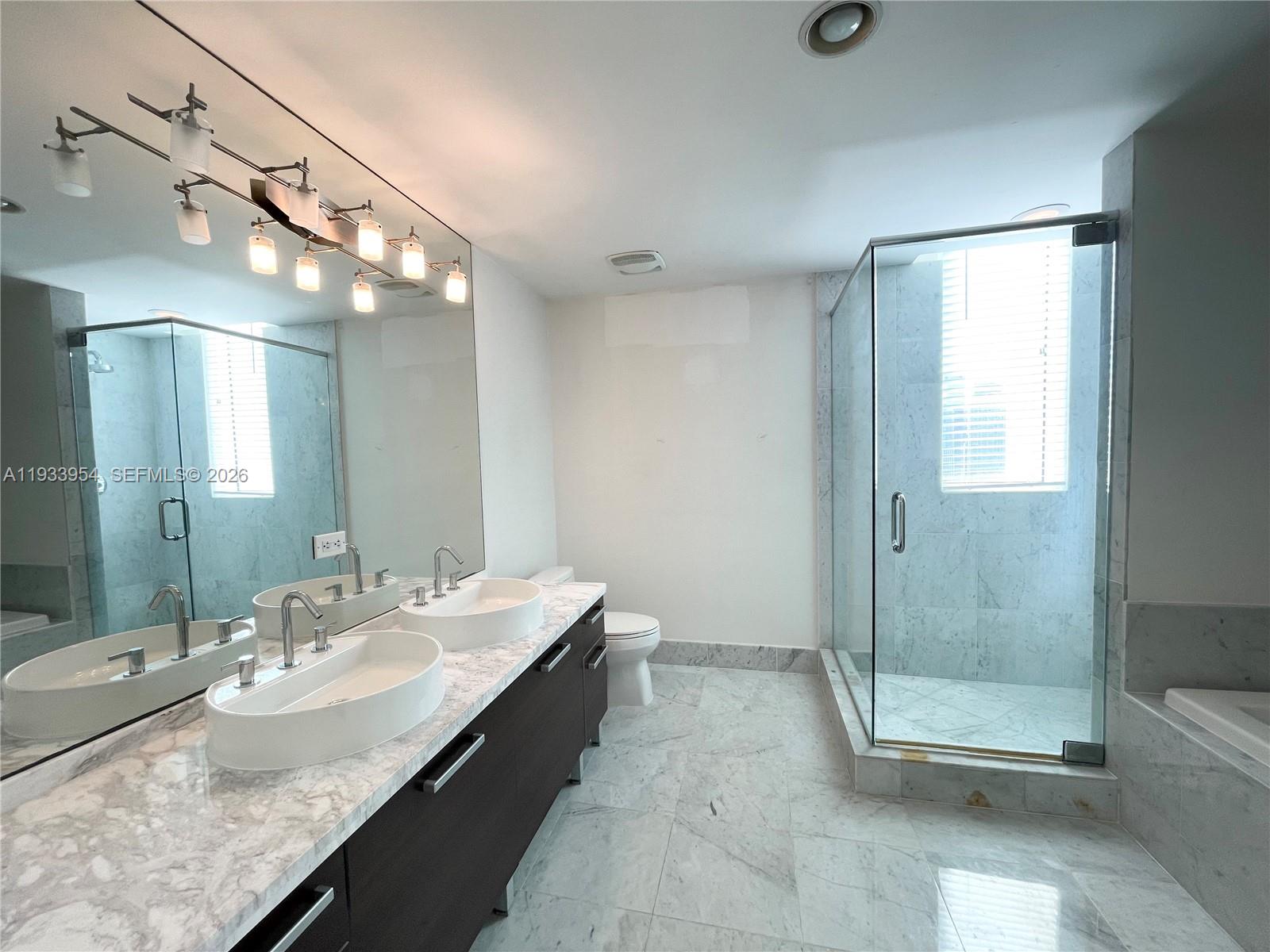 253 Northeast 2nd Street, Unit 2409 Miami, FL 33132 - Photo 35 of 61 a bathroom with a granite countertop sink a toilet and shower