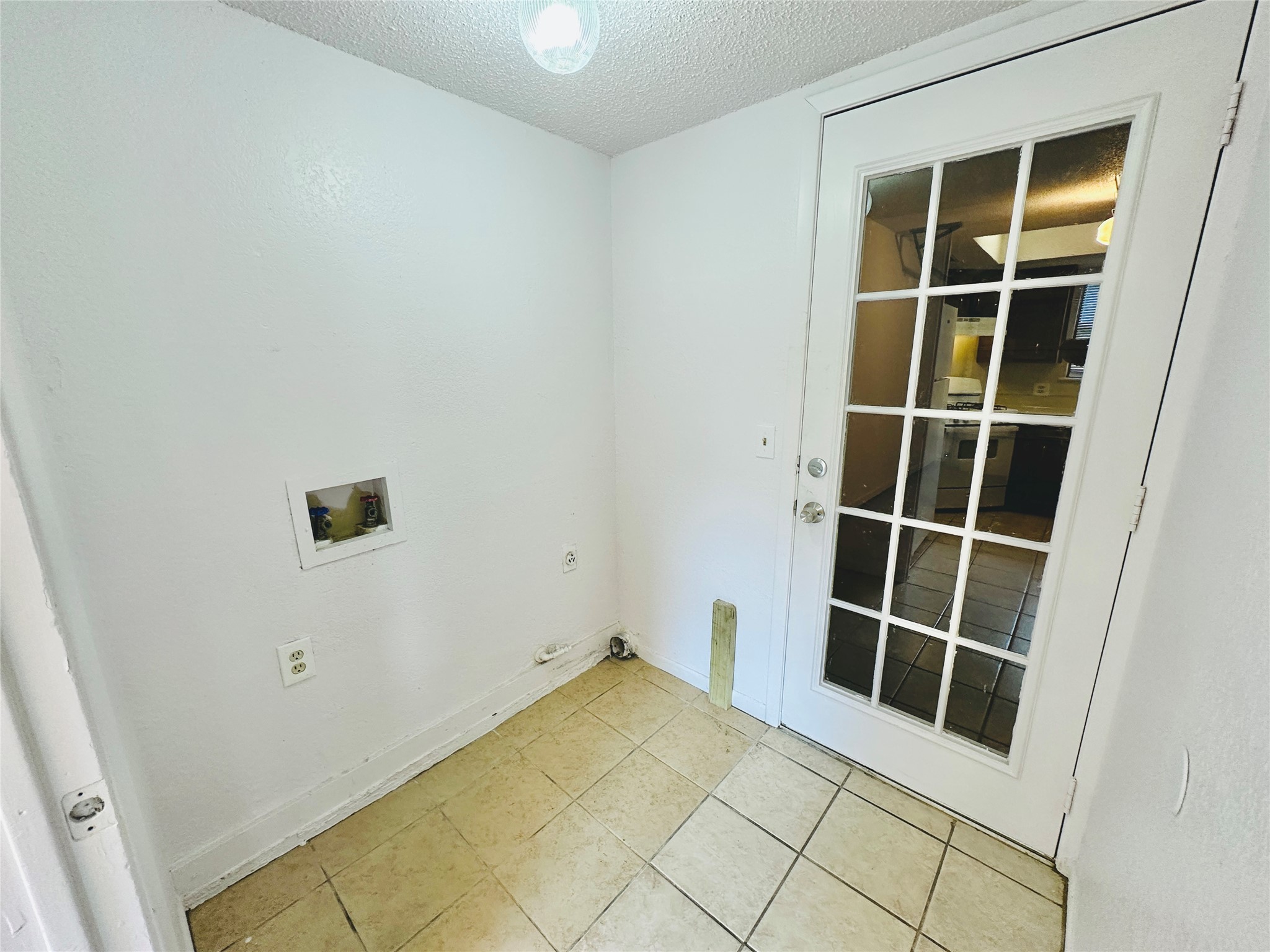 1002 Ridgemont Street Round Rock, TX 78664 - Photo 16 of 30 Laundry area featuring a textured ceiling, washer hookup, and light tile patterned floors