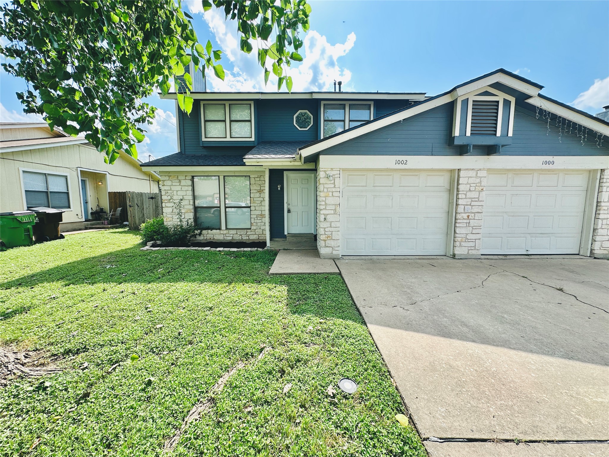 1002 Ridgemont Street Round Rock, TX 78664 - Photo 2 of 30 Traditional home featuring stone siding, concrete driveway, a front lawn, and a garage