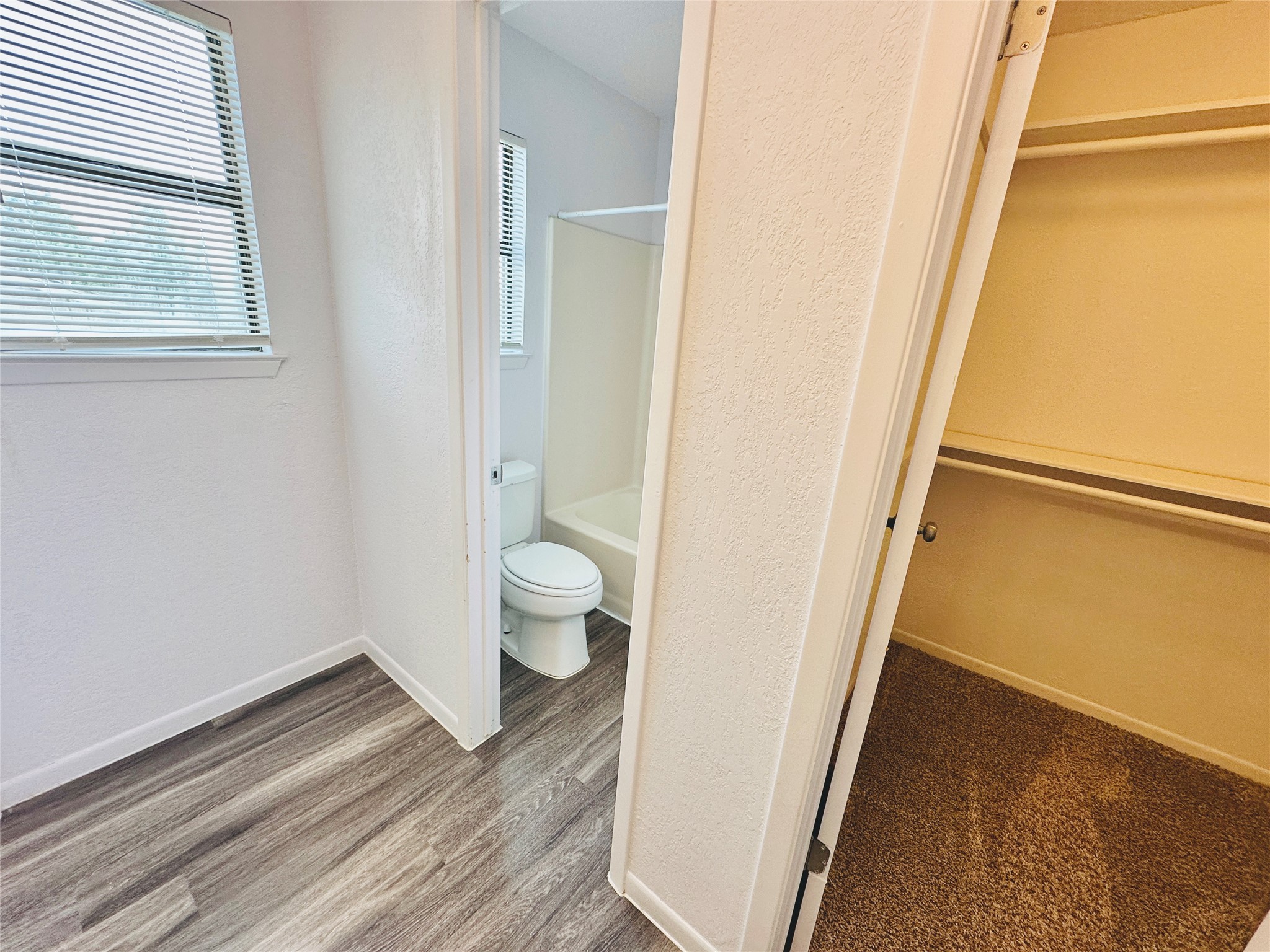 1002 Ridgemont Street Round Rock, TX 78664 - Photo 22 of 30 Full bathroom with wood finished floors, a textured wall, shower / bathtub combination, and a spacious closet