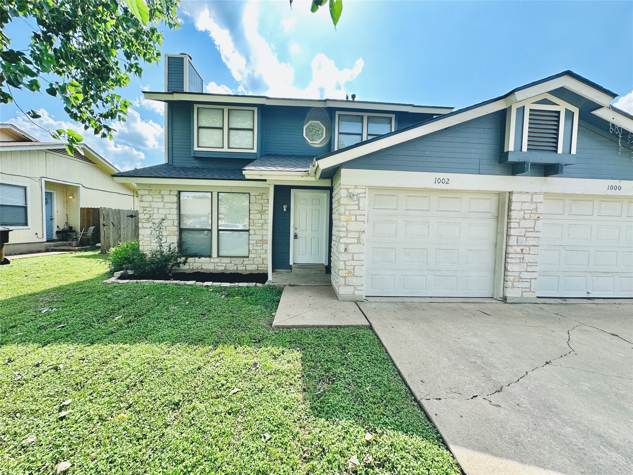 1002 Ridgemont Street Round Rock, TX 78664 - Photo 3 of 30 Traditional home with stone siding, driveway, a front yard, a chimney, and an attached garage