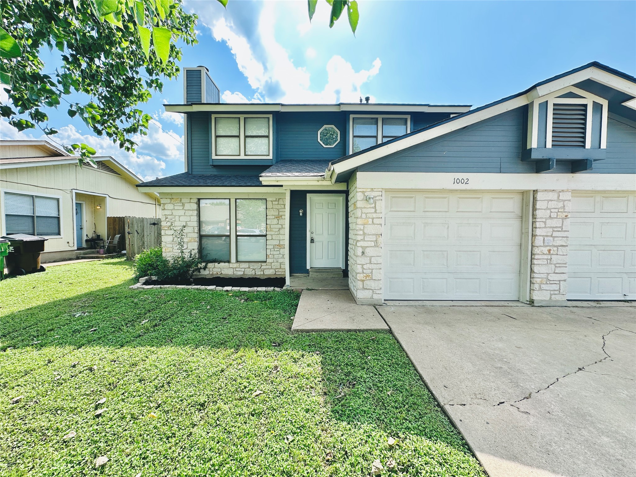1002 Ridgemont Street Round Rock, TX 78664 - Photo 4 of 30 Traditional-style home with stone siding, concrete driveway, a front lawn, a chimney, and a shingled roof