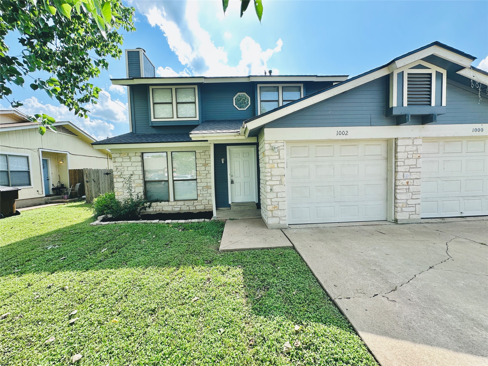 1002 Ridgemont Street Round Rock, TX 78664 - Photo 5 of 30 Traditional-style home with stone siding, driveway, a chimney, an attached garage, and a shingled roof