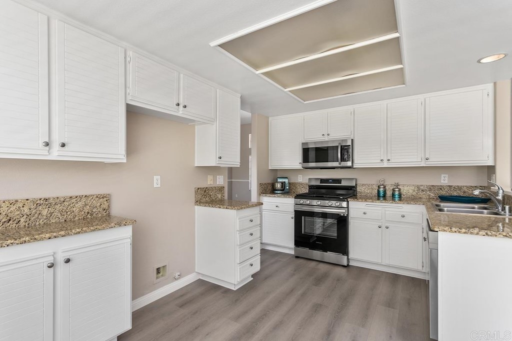 1865 Ithaca Drive Vista, CA 92081 - Photo 11 of 31 a kitchen with granite countertop white cabinets and stainless steel appliances