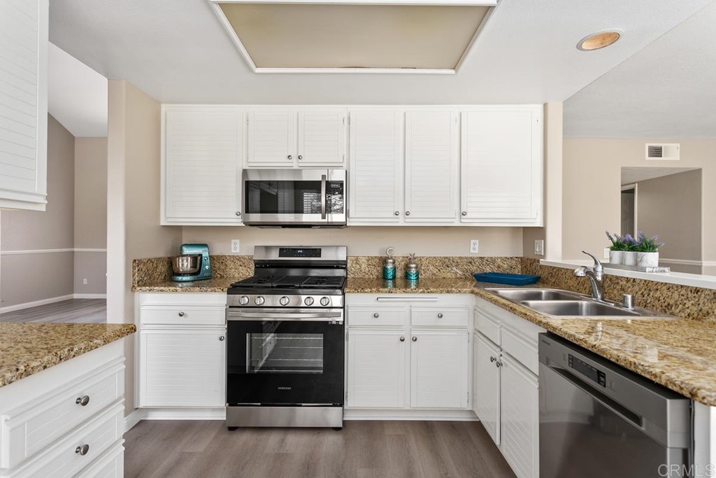 1865 Ithaca Drive Vista, CA 92081 - Photo 12 of 31 a kitchen with granite countertop white cabinets and white appliances