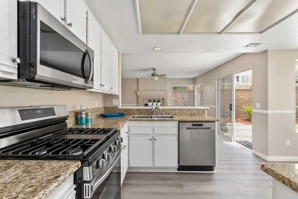 1865 Ithaca Drive Vista, CA 92081 - Photo 15 of 31 a kitchen with stainless steel appliances a sink a stove top oven a counter space and cabinets