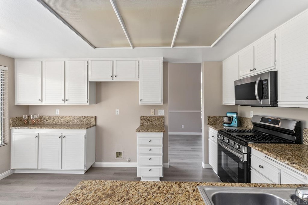 1865 Ithaca Drive Vista, CA 92081 - Photo 17 of 31 a kitchen with stainless steel appliances granite countertop a stove and a refrigerator