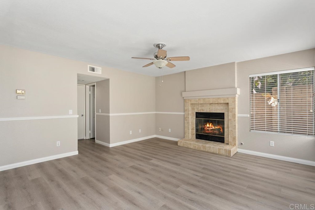 1865 Ithaca Drive Vista, CA 92081 - Photo 18 of 31 an empty room with wooden floor a fireplace and windows