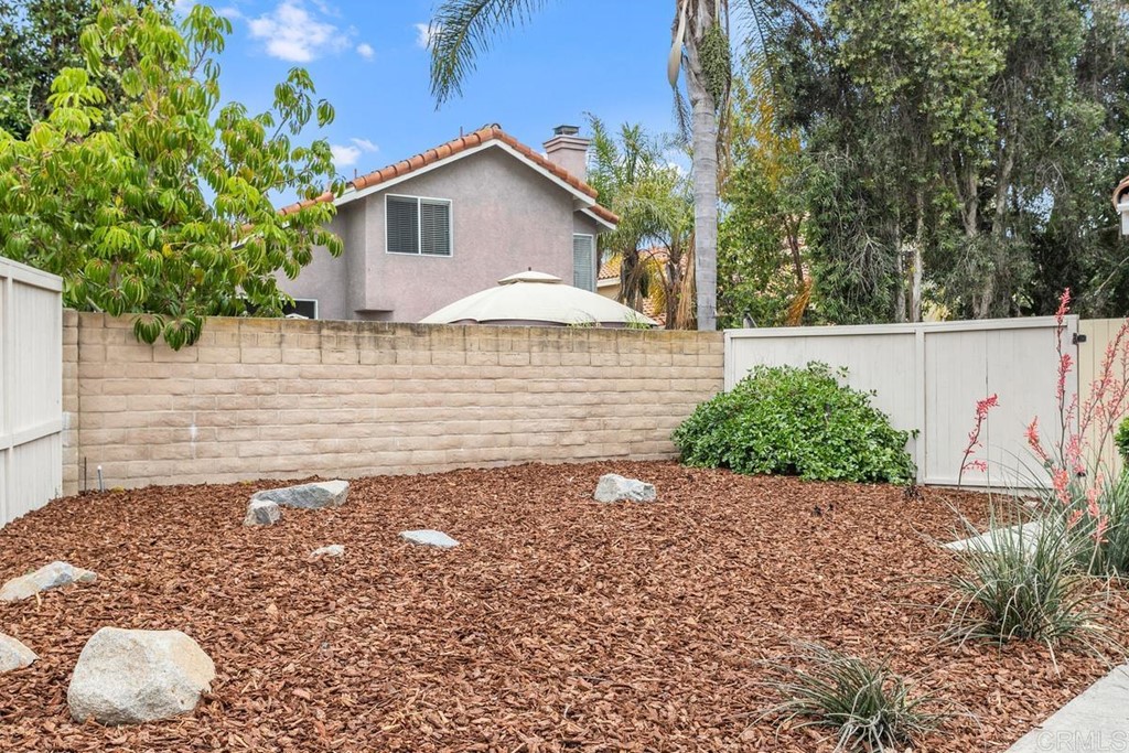 1865 Ithaca Drive Vista, CA 92081 - Photo 30 of 31 a white house with a small yard and large trees