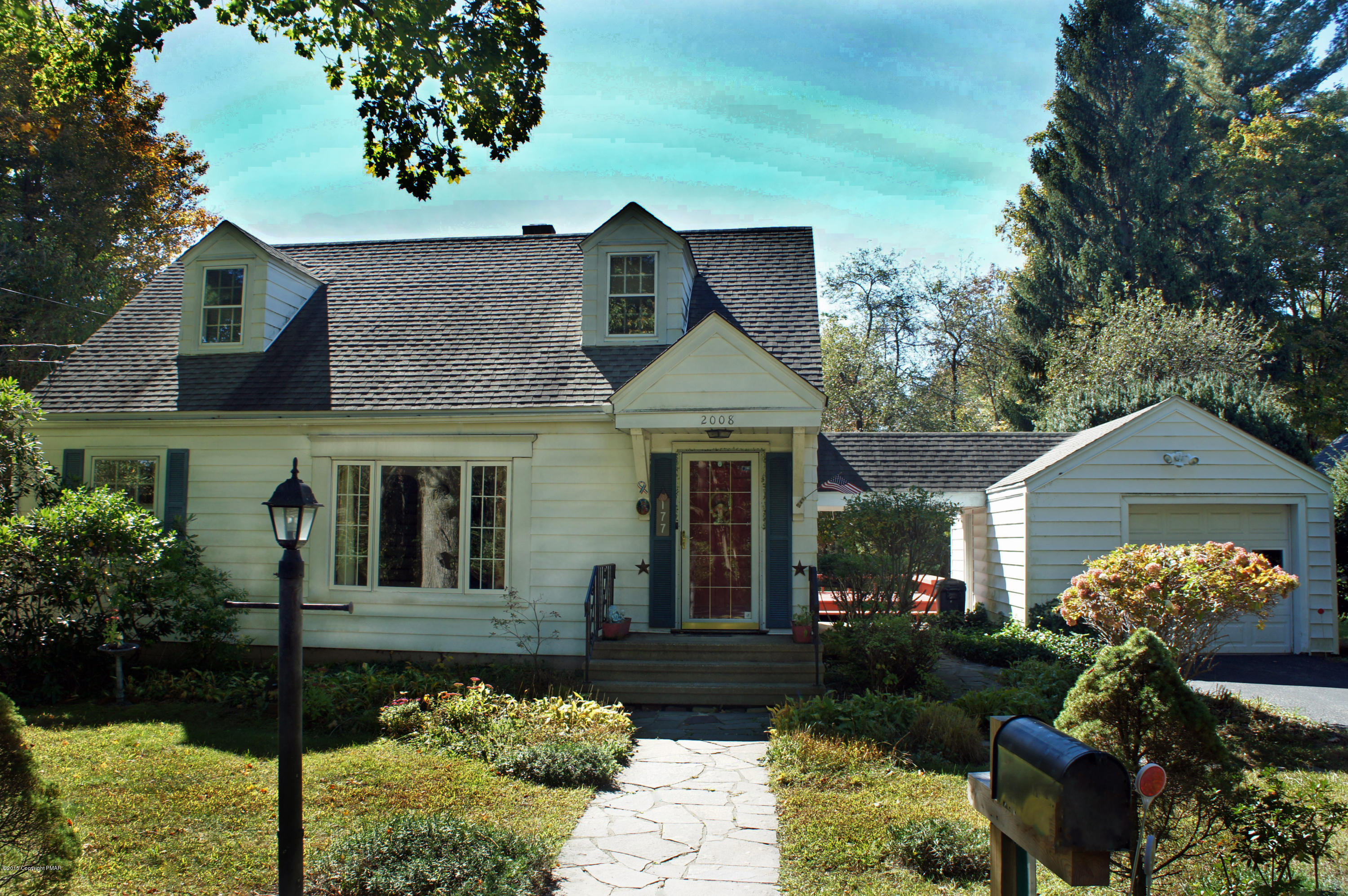 a front view of a house with a garden