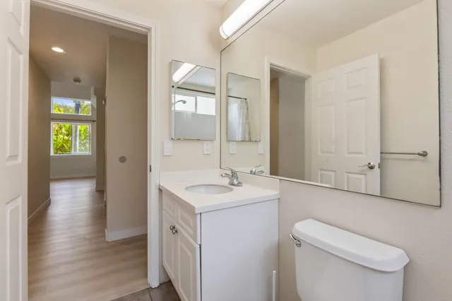 a spacious bathroom with a toilet sink and mirror