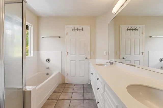 a bathroom with a tub sink and mirror