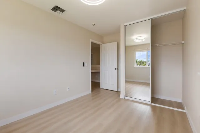 an empty room with wooden floor and mirror