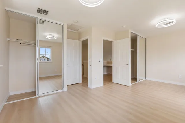 an empty room with closet and wooden door