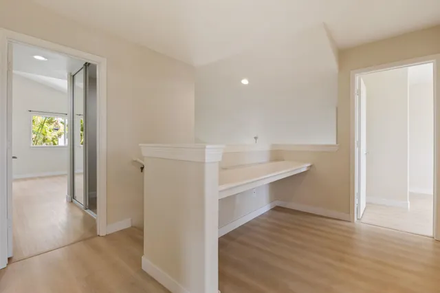a view of hallway with wooden floor and window