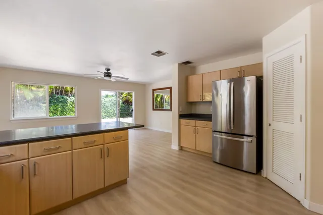 a kitchen with stainless steel appliances a refrigerator sink and wooden floor
