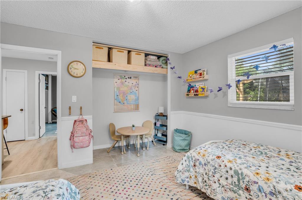 2905 Sunset Road Fort Myers, FL 33901 - Photo 18 of 18 a bedroom with a bed and a chandelier