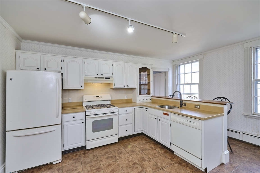 74 Washington Square, Unit 2 Salem, MA 01970 - Photo 11 of 31 a kitchen that has a lot of white cabinets and stainless steel appliances