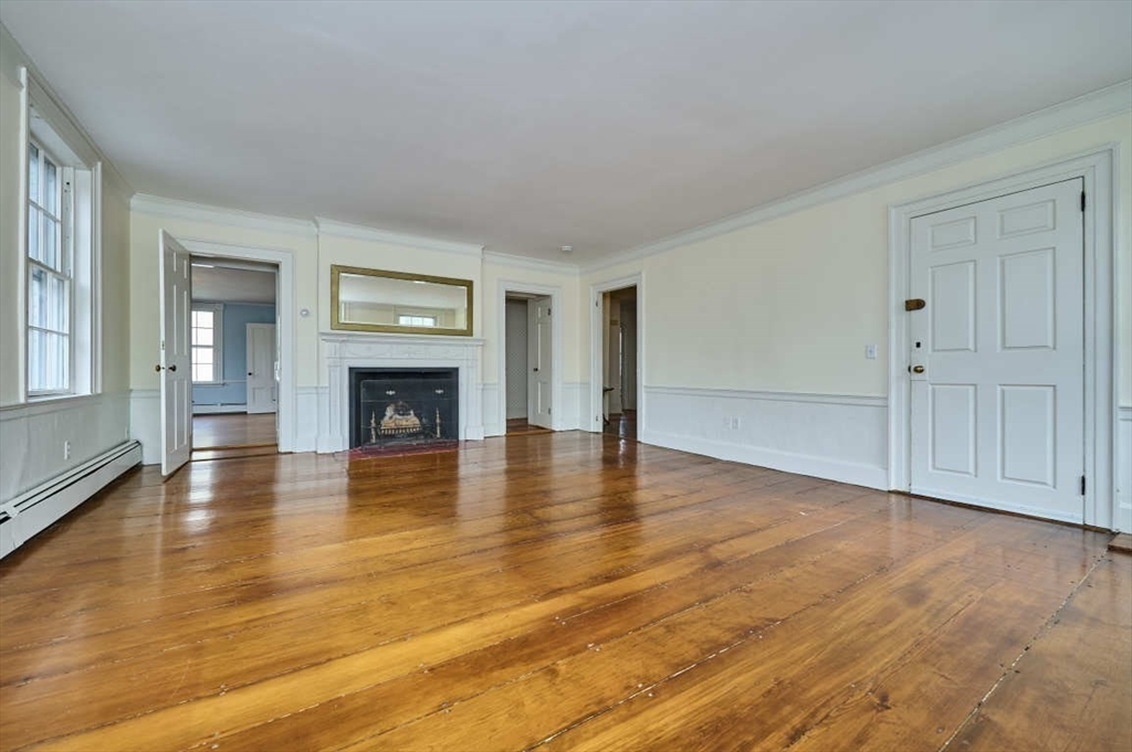 74 Washington Square, Unit 2 Salem, MA 01970 - Photo 2 of 31 an empty room with wooden floor and fireplace